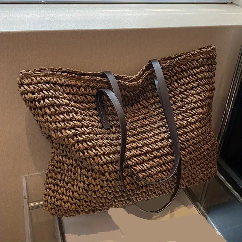 Fashionable women's oversized straw beach bag, an essential summer style accessory for vacations.