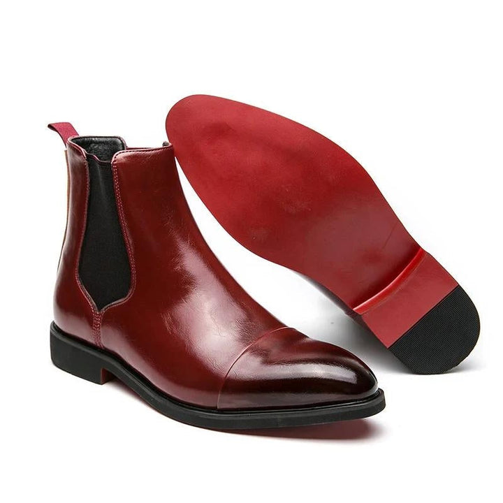 Sleek black leather Chelsea boots for men, combining classic style with a modern red sole detail.