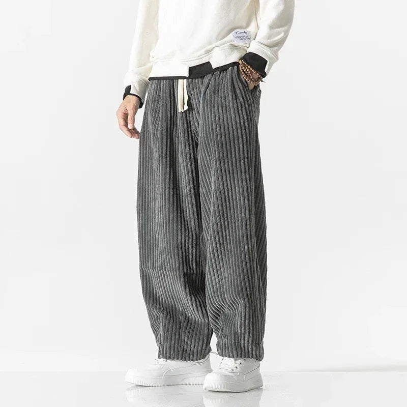 Folded men's wide-leg joggers, emphasizing comfort & style; versatile casual pants for everyday wear & loungewear.