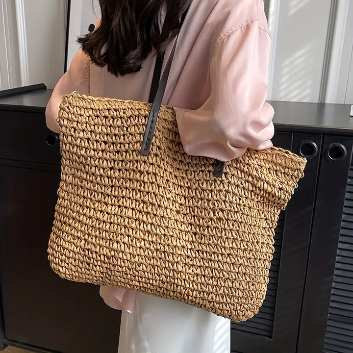 Large capacity women's oversized straw tote, essential for carrying beach gear & vacation items.