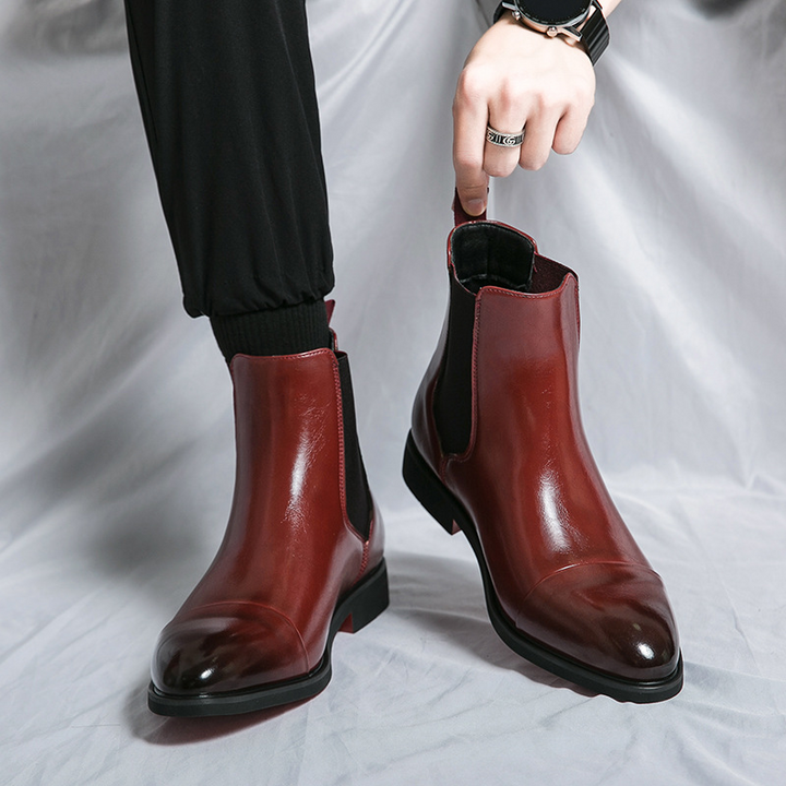 Dress up or down with these stylish men's black Chelsea boots, featuring a bold signature red sole.