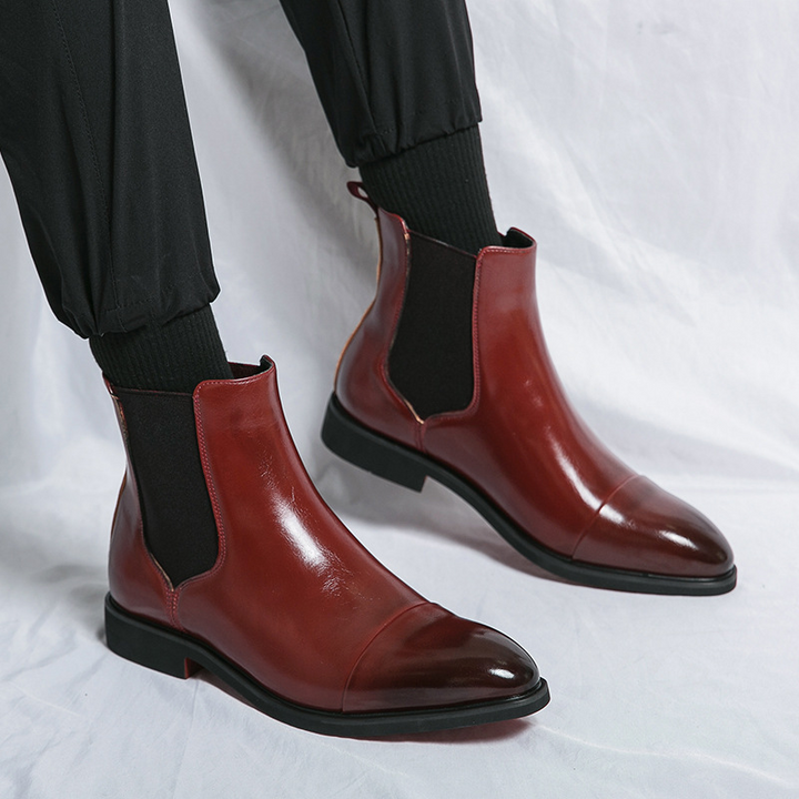 Step out in style with these men's black leather Chelsea boots, featuring a signature red sole.