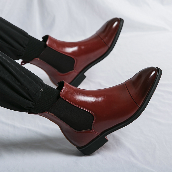 Elegant men's slip-on ankle boots, black Chelsea design, perfect for dressy or casual looks, red sole.
