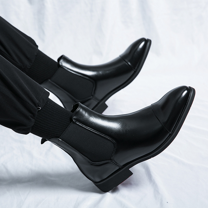 Versatile men's black Chelsea boots for formal or casual outfits, featuring a distinctive red sole.