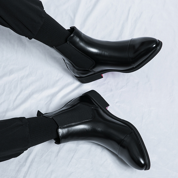 Premium black leather Chelsea boots for men, elegant slip-on design with a striking red sole.