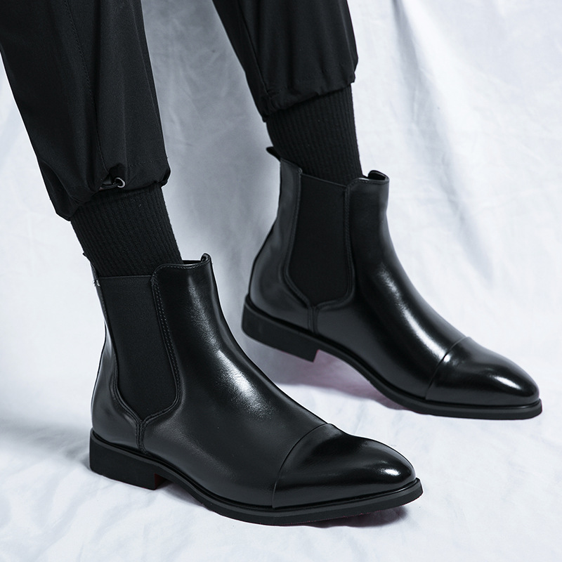 Modern men's fashion boots: sleek black Chelsea design, high-quality leather, iconic red sole accent.