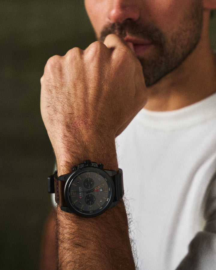 Close-up of a men's classic chronograph watch with a rich brown genuine leather band.