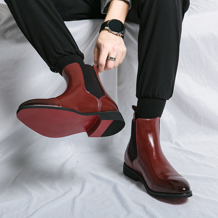 Iconic men's fashion boots: black leather Chelsea, slip-on convenience, and a signature red sole.