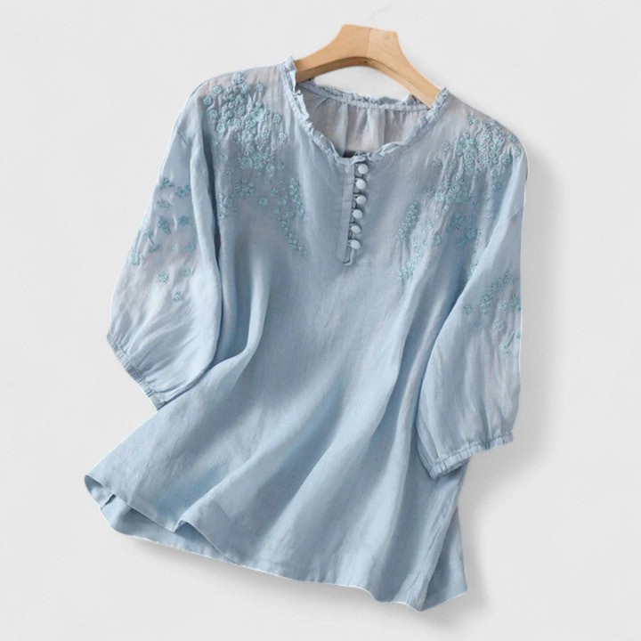 Chic women's blouse featuring delicate embroidery, a vintage-style ruffle collar & charming pom-pom details.