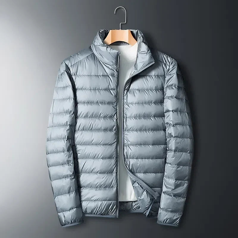 Unisex lightweight packable puffer jacket in blue, perfect for outdoor travel & cold weather adventures.