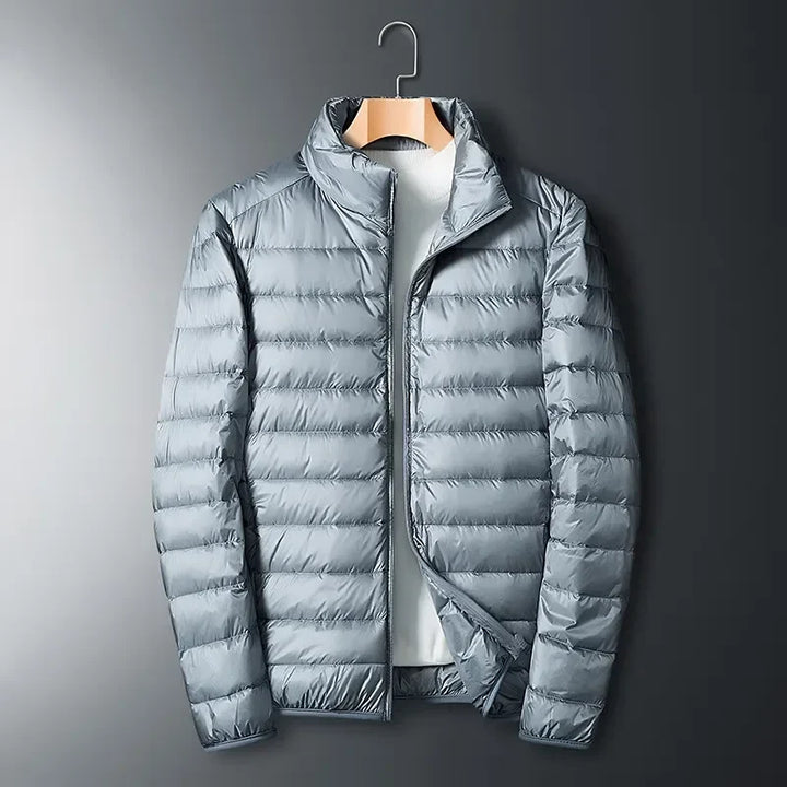 Unisex lightweight packable puffer jacket in blue, perfect for outdoor travel & cold weather adventures.