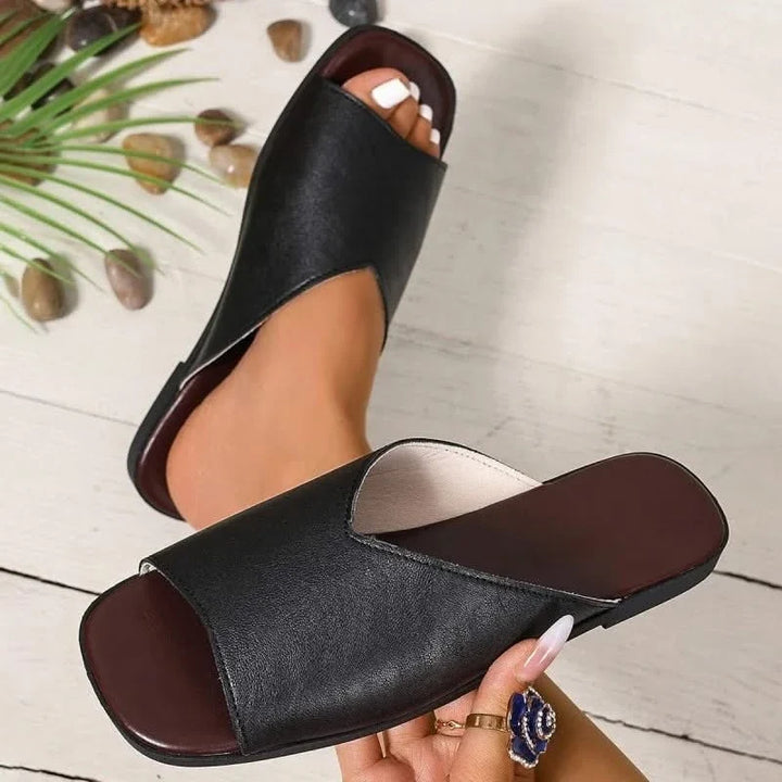 Front view of women's open-toe flats, showcasing their sleek design for summer outfits.