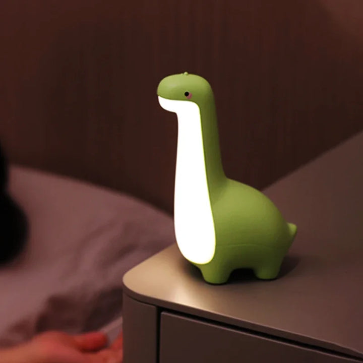 Adorable green silicone dinosaur night light for kids' rooms, providing a soft, comforting glow.