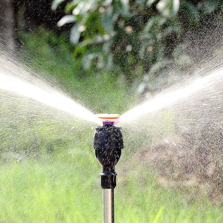"Automatischer rotierender Gartensprinkler mit Stativ und flexiblem Sprühmechanismus im Garten platziert"