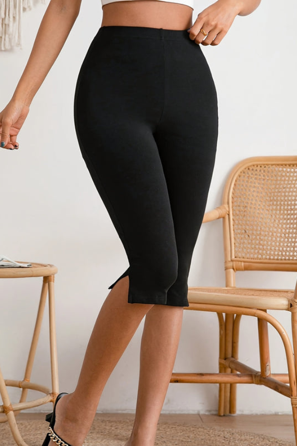 Women's black stretch slim-fit cropped pants with a trendy slit hem, ensuring comfort and style for any occasion.