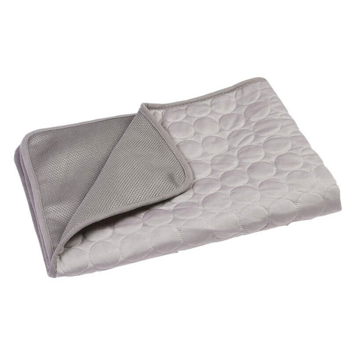 Self-cooling pet mat with a dog toy nearby, highlighting pet comfort and play area