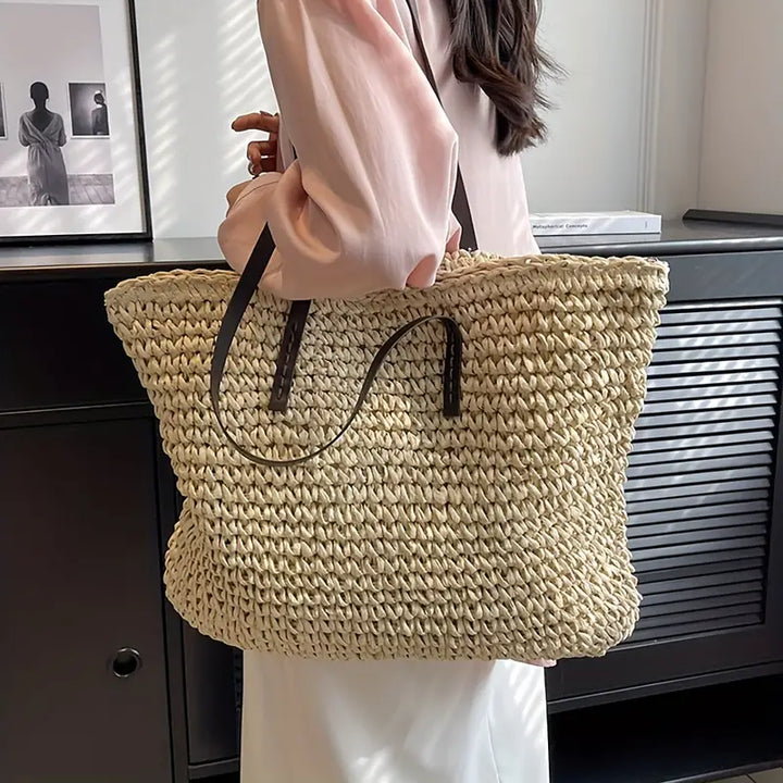 Natural texture of a women's oversized woven straw beach tote bag, highlighting summer fashion.