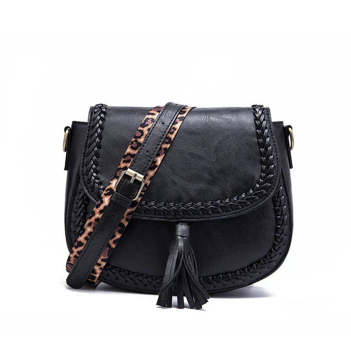 Women's versatile black saddle bag with a chic tassel detail and fully adjustable strap.