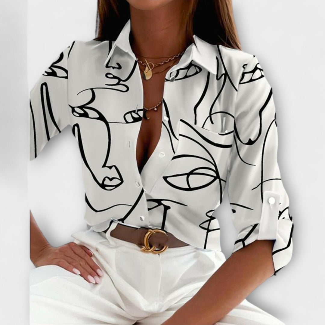 Long sleeve cuff detail of a women's abstract print button-down blouse, modern design.