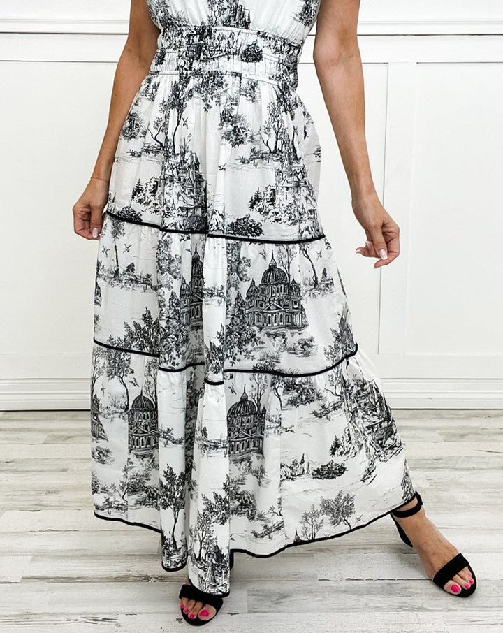 Chic women's wedding guest attire: printed tiered maxi dress with puff sleeves and smocked waist detail.