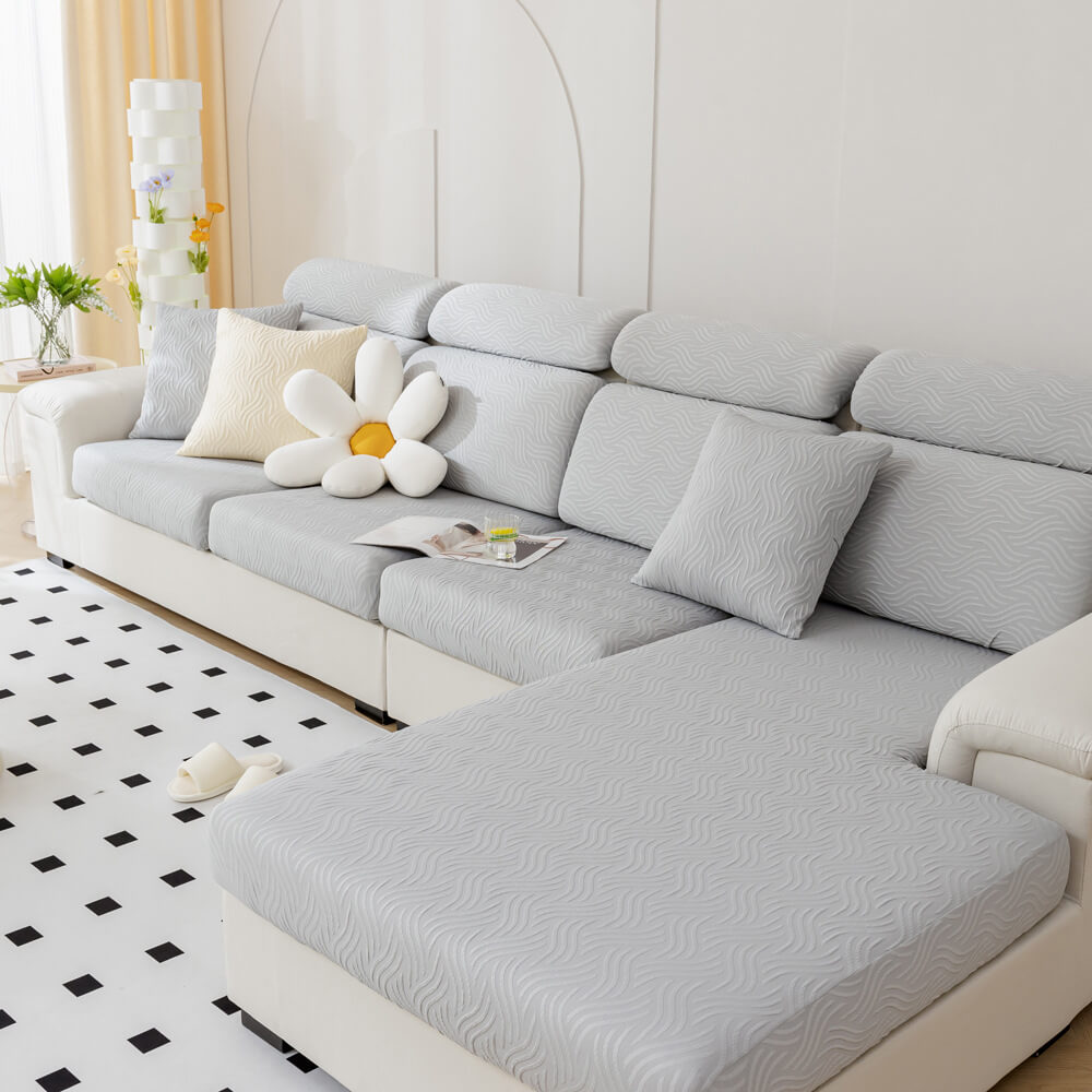 Three different color options: gray, blue, and beige cooling stretch sofa covers folded neatly