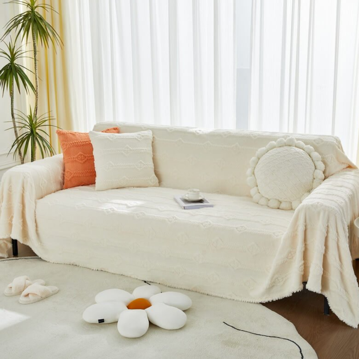 Cozy faux fur sofa cover in a light color, draped over a living room couch, soft and plush for furniture protection.