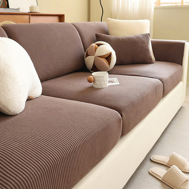 "Elastischer Sofabezug aus kratzfestem Cord mit eleganten vertikalen Streifen, passt zu modernen Wohnzimmern."