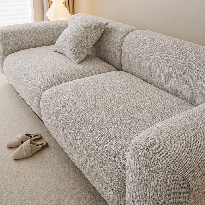 Full view of a living room with elegant chenille stretch sofa cover protecting a couch