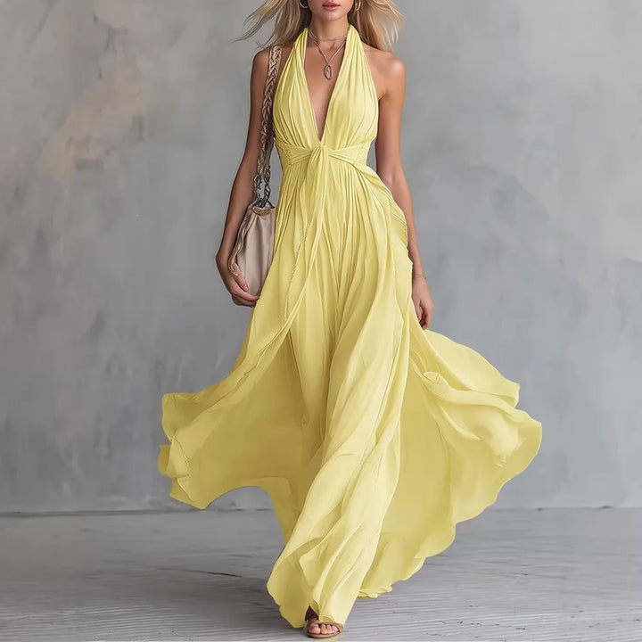 Long pleated backless evening dress for women, featuring a beautiful flowy skirt and elegant halter neckline.