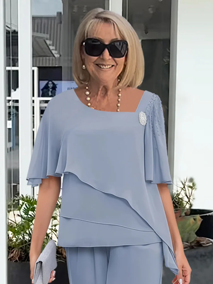 Women's elegant formal two-piece set: a chic tiered cape top and matching wide-leg trousers for events.