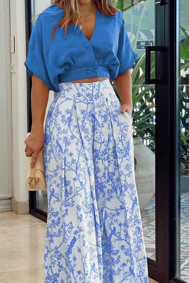 Fashionable women's V-neck blouse & wide leg pants outfit. An elegant two-piece set for chic summer style.