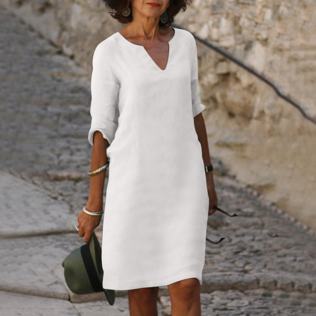 Neatly folded women's V-neck summer midi dress, comfortable and elegant for travel or casual wear.