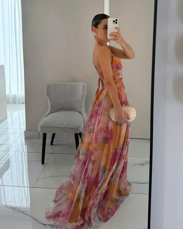 Women's long maxi dress featuring a vibrant watercolor floral print and stylish twist front, suitable for events.