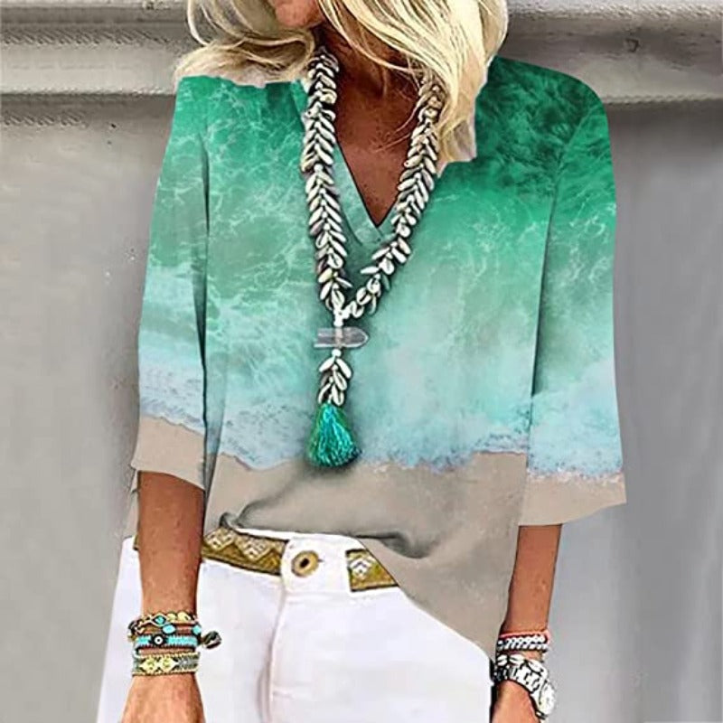 Elegante, luftige Damenbluse mit kristallblauen Nuancen und sandigen Tönen, V-Ausschnitt und weiten Ärmeln.