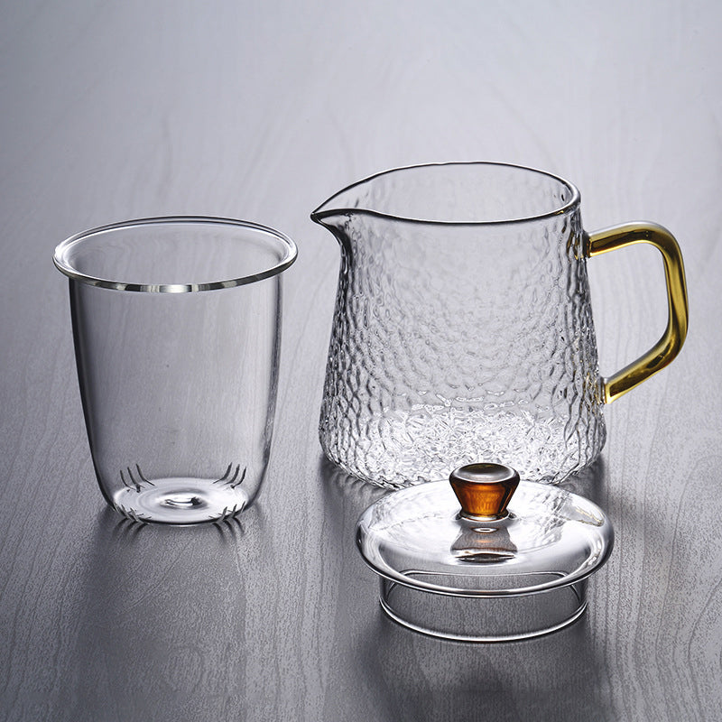 Elegante Teekanne aus gehämmertem, hitzebeständigem Glas mit integriertem Sieb und goldfarbenem Griff. Ideal für Teegenuss.