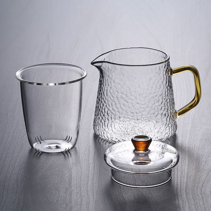 Elegante Teekanne aus gehämmertem, hitzebeständigem Glas mit integriertem Sieb und goldfarbenem Griff. Ideal für Teegenuss.