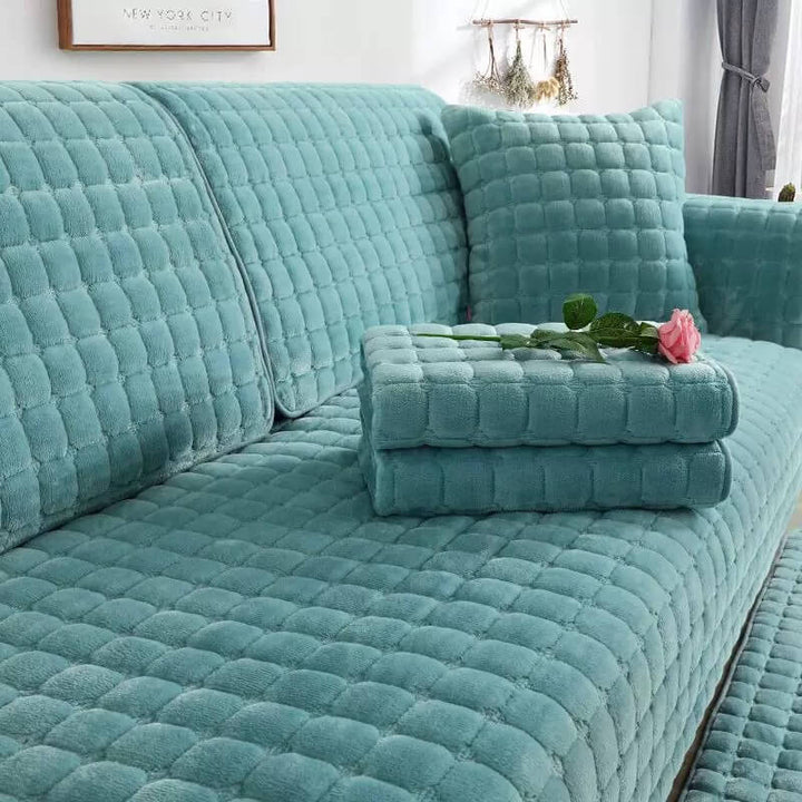 Flannel quilted couch cover in a living room setting, showcasing non-slip scratch-resistant design