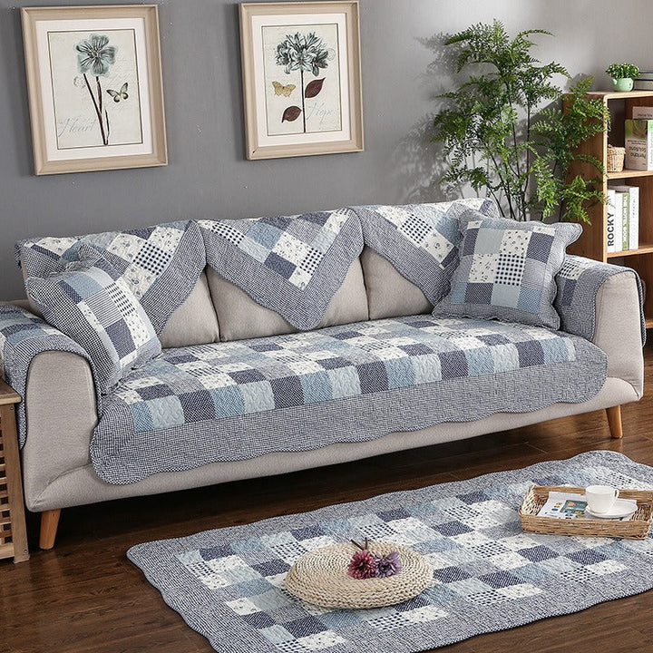 Washable quilted cotton furniture protector in beige, covering a three-seater sofa, non-slip design.