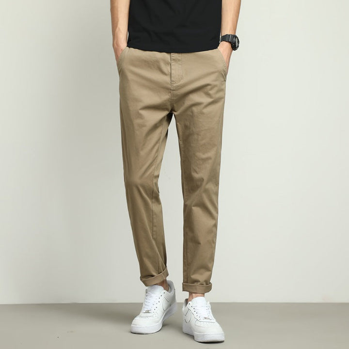 Black men's slim-fit performance tech trousers. Stretch, wrinkle-free & water-resistant for travel or work.