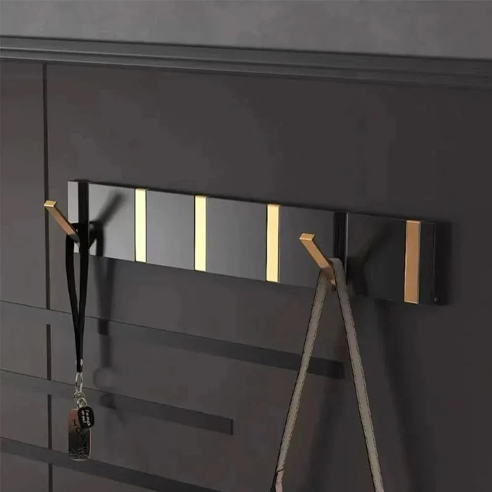 Modern folding aluminum wall hook for space-saving home organization. Perfect for coats, towels.