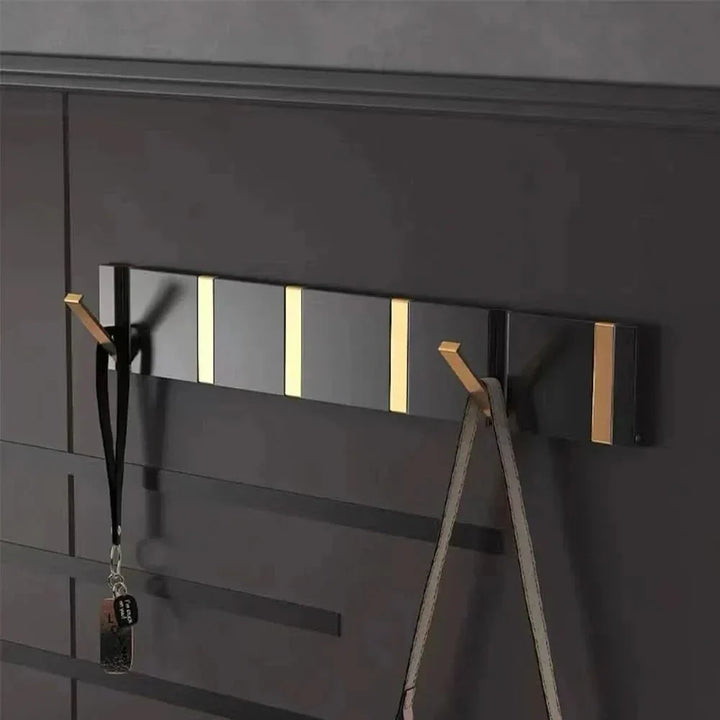 Modern folding aluminum wall hook for space-saving home organization. Perfect for coats, towels.