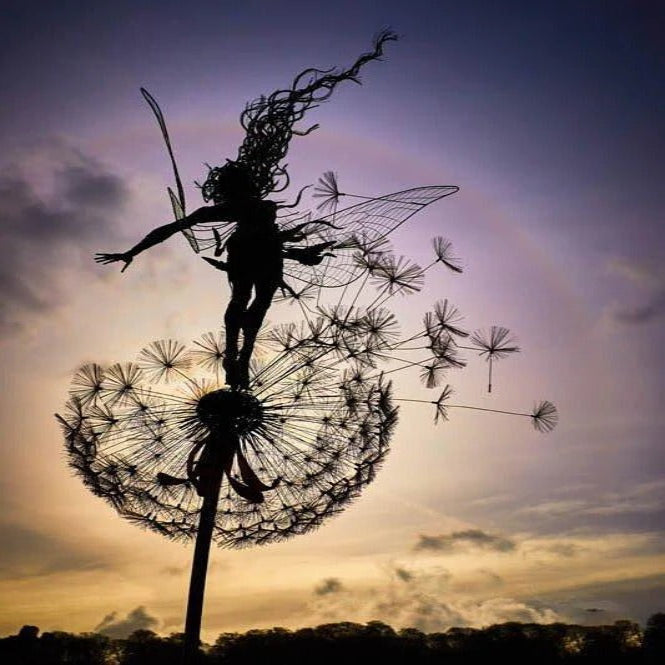 Elegant metal fairy sculpture soaring from a dandelion, perfect garden stake ornament.