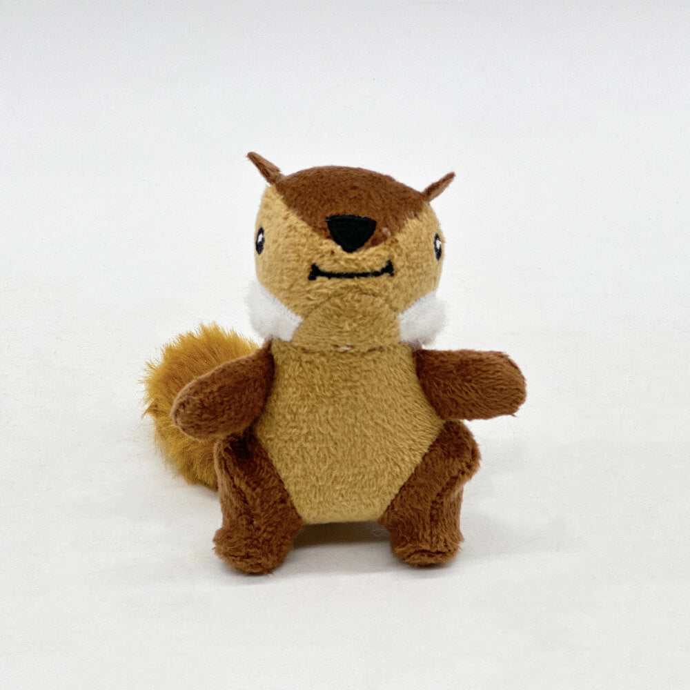 Dog playing with a brown interactive tree trunk toy, pulling out a plush squeaky squirrel