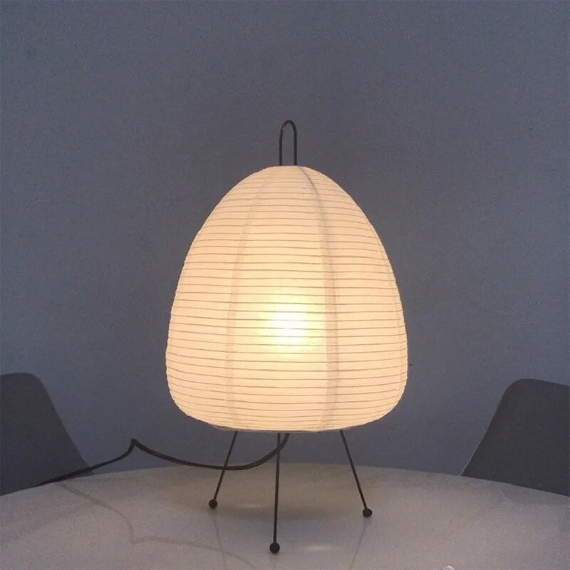 Japanische Tischlampe mit Reispapier, strahlt warmes, diffuses Licht aus, elegantes und zeitloses Design für Innenräume.