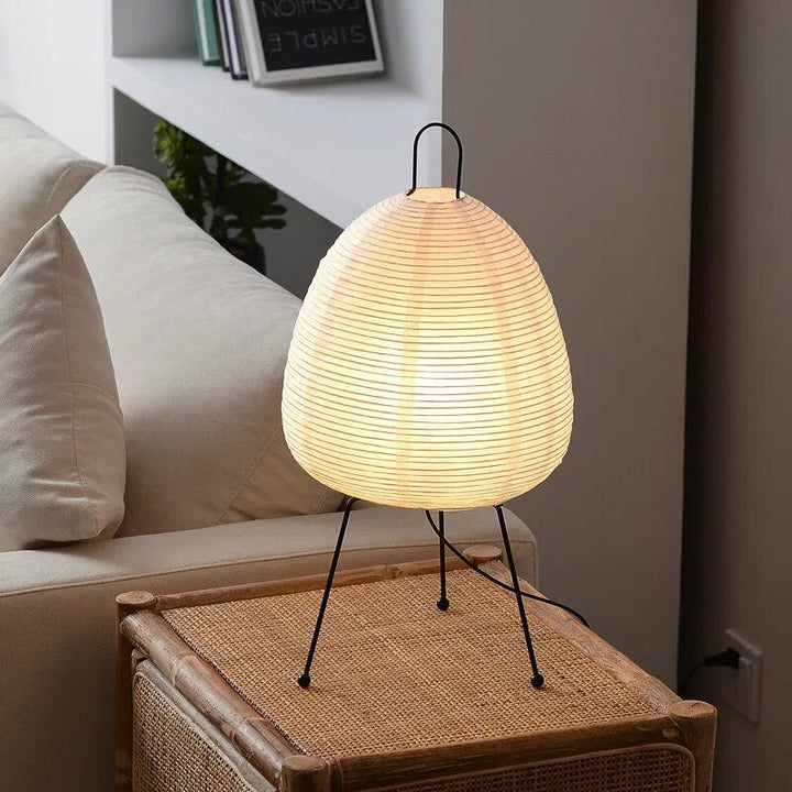 Japanische Tischlampe mit Reispapier, strahlt warmes, diffuses Licht aus, elegantes und zeitloses Design für Innenräume.