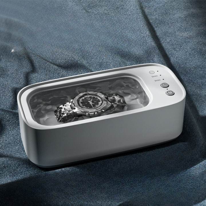 Kompaktes Ultraschallreinigungsgerät in Blau-Gelb für effektive Reinigung von Schmuck, Uhren und Brillen.