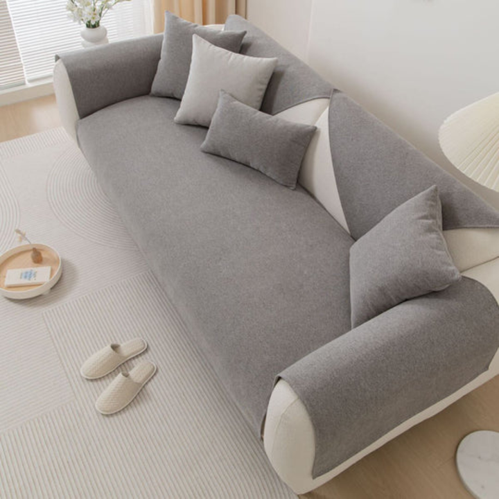 View of a modern sectional sofa covered by a blue linen blend slipcover with non-slip backing