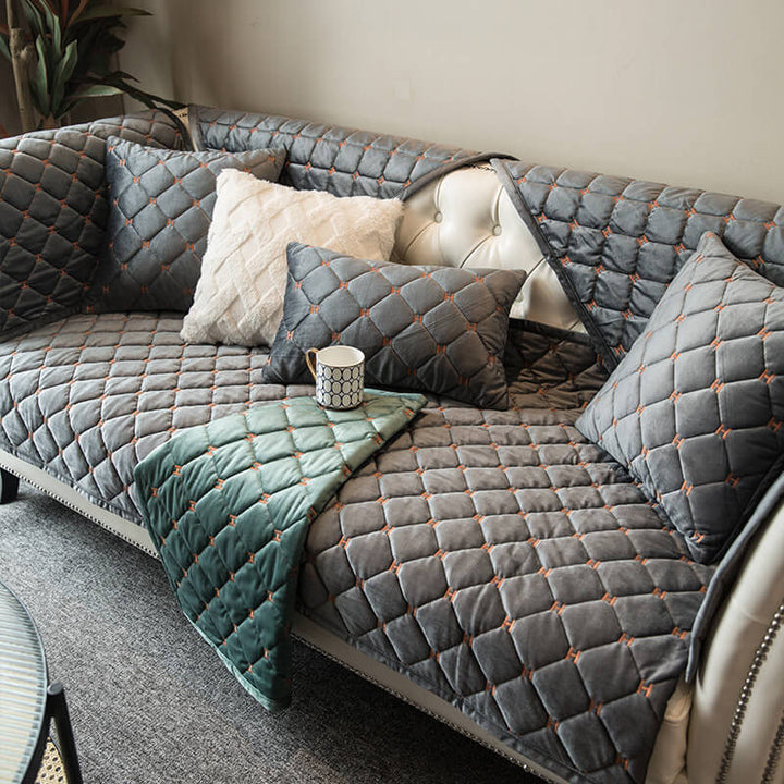 Luxury velvet quilted non-slip sofa cover in elegant grey, protecting furniture & enhancing home decor.