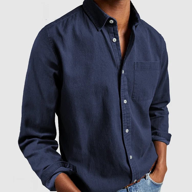Close-up of durable men's blue denim button-up shirt fabric, showcasing timeless texture & quality stitching.