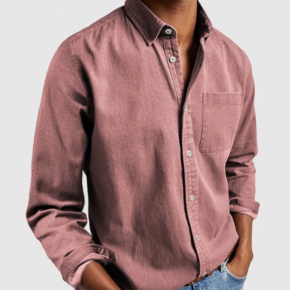 Men's long sleeve denim button-up shirt worn open over a tee, illustrating casual layering & versatile fashion.